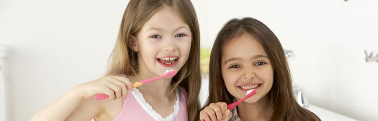 Two girls brushing their teeth