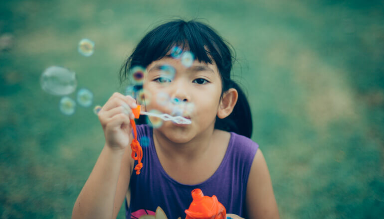little girl blowing bubbles