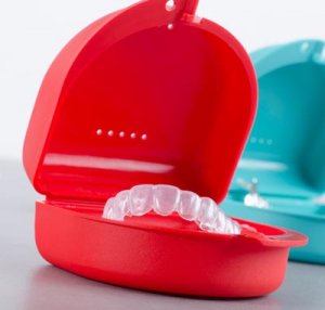 teeth whitening trays in red and blue cases