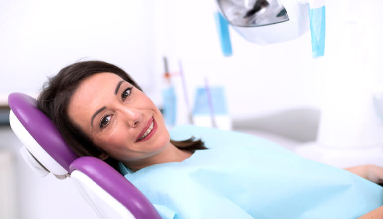 Brunette lady in dental chair awaiting root canal therapy