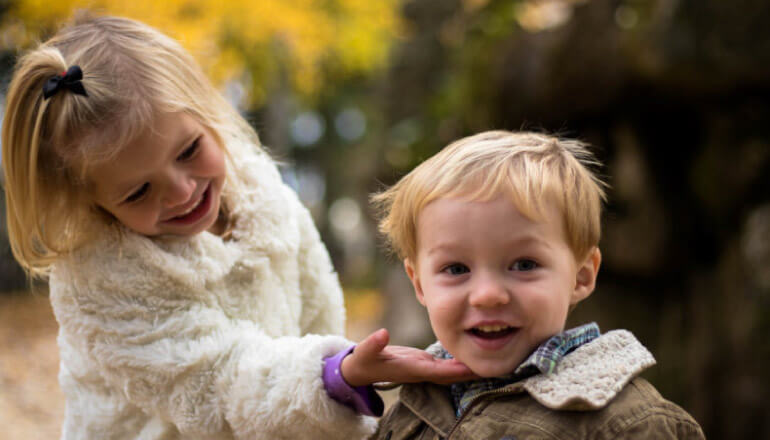 young girl shows off her baby brothers dental sealants