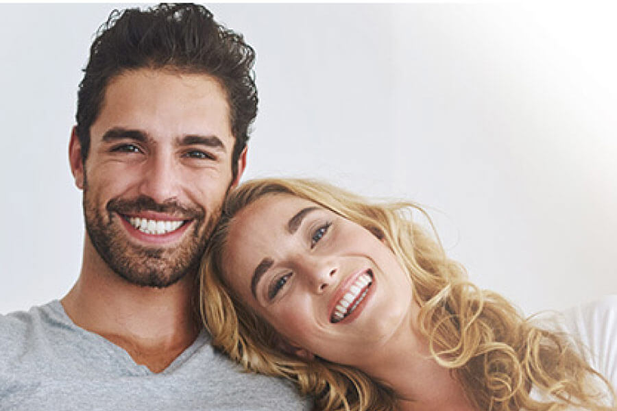 young couple smile after getting invisalign clear aligners