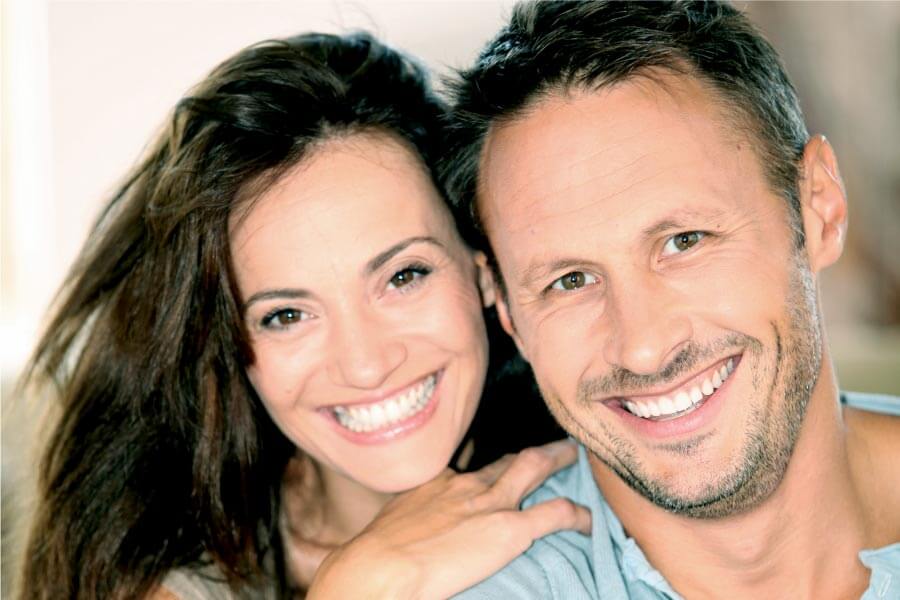 young couple smile showing off results from professional teeth whitening treatments